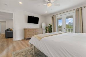a bedroom with a large bed and a television at The Sunny Side-Pensacola Beach, 600 feet to Gulf, Private/Heated Pool, Games, Gear in Pensacola Beach +41 photos