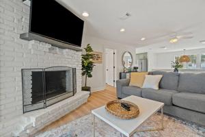 a living room with a couch and a fireplace at The Sunny Side-Pensacola Beach, 600 feet to Gulf, Private/Heated Pool, Games, Gear in Pensacola Beach
