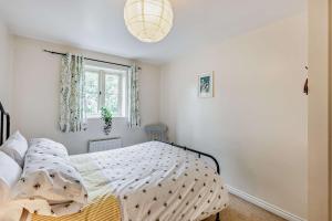 a bedroom with a bed and a window at Tall Trees. Luxury North Cotswold cottage in Banbury