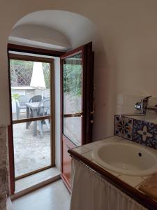 La salle de bains est pourvue d'un lavabo et d'une porte de patio. dans l'établissement Luxury Trulli sabotino, à Alberobello