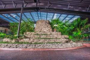 a large stone structure in a building with plants at Family Garden Inn & Suites in Laredo