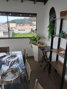 a dining room with a table and chairs and a window at Villa Bonita praia in Palhoça
