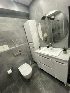 a bathroom with a toilet and a sink and a mirror at 2-х комнатная квартира #Inamstro Apartament cu 2 camere cu TERASA in Chişinău