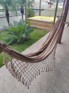 a hammock in a garden with a bed at Villa Bonita praia in Palhoça