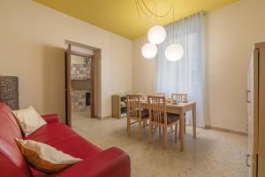 ローマにあるB&B L'Amacaのリビングルーム(赤いソファ、テーブル付)