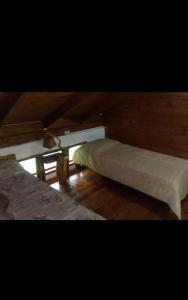 a room with two beds and a table in it at Cabaña con Costa de Rio in El Hoyo