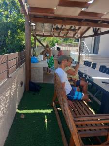 duas pessoas sentadas num banco debaixo de uma pérgula em Giannis Villa em Skinés