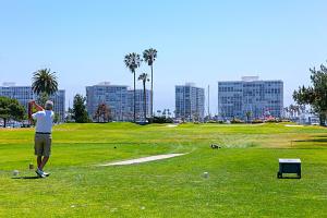 een man speelt golf op een golfbaan bij Coronado Seaside Cottage in San Diego