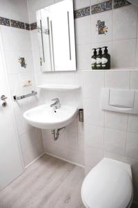 a white bathroom with a toilet and a sink at Calm and Cozy apartment Bivange in Livange