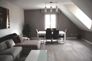 ein Wohnzimmer mit einem Tisch und einem Sofa in der Unterkunft Calm and Cozy apartment Bivange in Livange