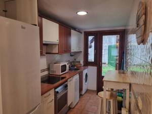 uma cozinha com um frigorífico branco e um micro-ondas em Casa Biniu em Villanúa