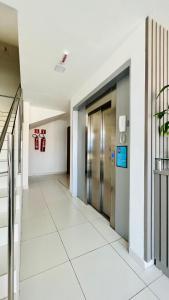 an empty hallway in an office building with a elevator at Hotel Pousada Kairos Manaira in João Pessoa