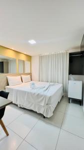 a bedroom with a large bed and a flat screen tv at Hotel Pousada Kairos Manaira in João Pessoa