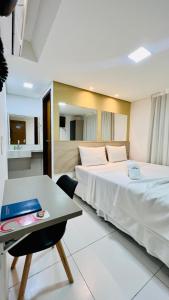 ジョアンペソアにあるHotel Pousada Kairos Manairaのベッド2台とテーブルが備わるホテルルームです。