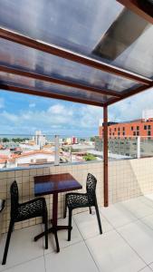 - Balcón con vistas, mesa y 2 sillas en Hotel Pousada Kairos Manaira, en João Pessoa