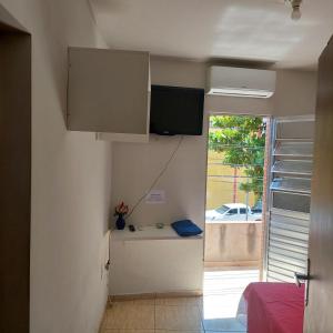 um quarto com uma cozinha com uma televisão na parede em Flat estação em Juazeiro do Norte