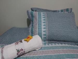 a bed with two pillows and a yellow flower on a pillow at Espaço Aconchego in Uberaba