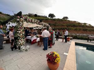 eine Gruppe von Menschen, die um ein Zelt mit Blumen stehen in der Unterkunft Quinta da Casa Cimeira, Guest House, Wines & Food in Valença do Douro