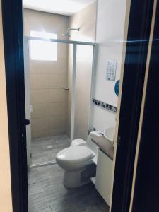 a bathroom with a toilet and a sink and a shower at White Coral ApartaSuites in San Andrés