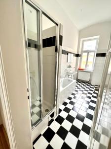 uma casa de banho com um chuveiro e um piso xadrez preto e branco em Iconic Suite_@O&R em Viena