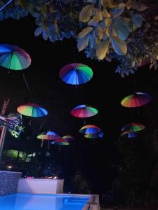 a group of colorful umbrellas hanging from a ceiling at JKO woodland resort in Malampay