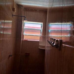 uma casa de banho com um chuveiro, uma janela e toalhas em Flat estação em Juazeiro do Norte