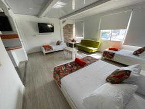 um quarto com uma cama e uma sala de estar com um sofá em La Posada De Lulú em San Andrés