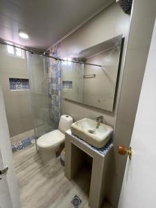 a bathroom with a sink and a toilet and a mirror at La Posada De Lulú in San Andrés