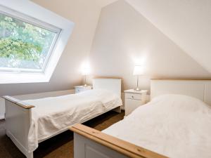 two beds in a attic bedroom with a window at Luxury apartment in central Barcelona in Lübberstorf