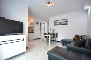 a living room with a couch and a flat screen tv at Apartament Glamour in Ustrzyki Dolne