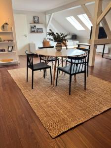 una sala da pranzo con tavolo e sedie su un tappeto di Tolles Studio Apartment nähe Leipzig a Wiedemar
