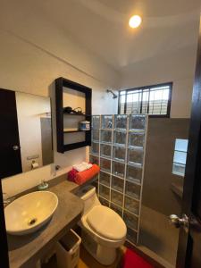 a bathroom with a white toilet and a sink at Casa del Sol in Tamarindo +48 photos
