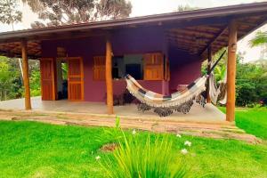 a purple house with a hammock in front of it at Casa de Miroca in Uruçuca +2 photos