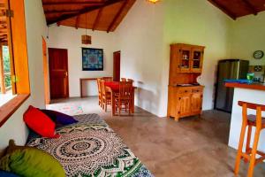 a room with a bed and a kitchen with a table at Casa de Miroca in Uruçuca