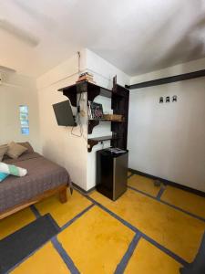 Casa del Sol في تاماريندو: غرفة صغيرة مع سرير وجدار مع علامة اتر
