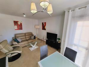 Apartamento Miró في كاليبي: غرفة معيشة مع أريكة وطاولة