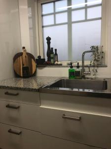 a kitchen counter with a sink and a window at Ett rum & kök in Bålsta
