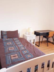 Bett in einem Zimmer mit einem Tisch und einem Schreibtisch in der Unterkunft Piso- Huesca Capital - with elevator in Huesca
