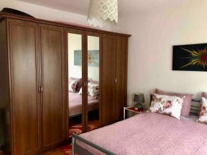 - une chambre avec une grande armoire en bois à côté d'un lit dans l'établissement Cozy, peaceful apartment near city center., à Peje