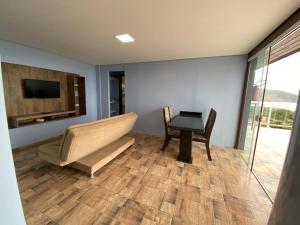 - un salon avec un canapé et une table dans l'établissement Residencial Gralha Azul, à Florianópolis