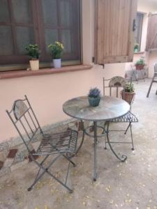 una mesa con dos sillas y una mesa con flores. en Appartamento Ginepro, en Capitana