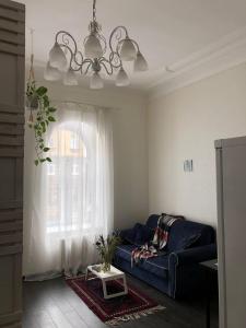 uma sala de estar com um sofá azul e uma janela em Makij apartment for night 4 em Narva