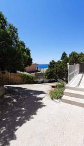 una acera con escaleras y una valla y el océano en Appartamento Ginepro, en Capitana