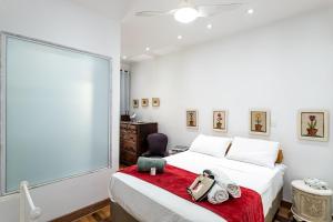 um quarto com uma cama com um cobertor vermelho e uma cadeira em Garden Rio - Facilidade e Tranquilidade! no Rio de Janeiro