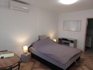 1 dormitorio con 1 cama y 1 mesa con 2 lámparas en Szépasszonyvölgy Apartman, en Eger