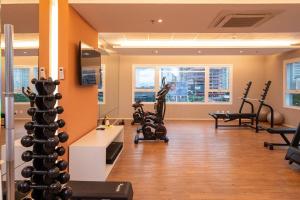 a gym with exercise equipment and a person in the window at Studios aconchegantes no Setor Marista BLS in Goiânia