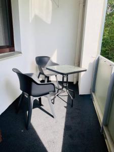 2 Stühle und ein Tisch in einem Zimmer mit Fenster in der Unterkunft Schönes Wohnen in Groß-Buchholz - Zentral+Modern in Hannover