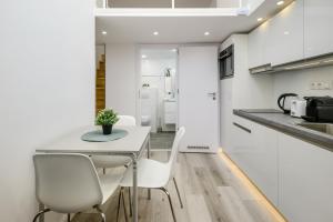 - une cuisine blanche avec une table et des chaises dans l'établissement VISEGRADI40 quality apartments, à Budapest