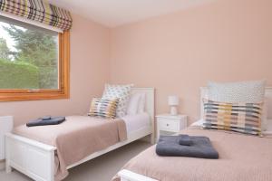 een slaapkamer met 2 bedden en een raam bij Ballater Bungalow - 4 bed - Beautiful Garden in Ballater