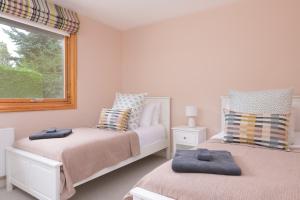a bedroom with two beds and a window at Ballater Bungalow - 4 bed - Beautiful Garden in Ballater